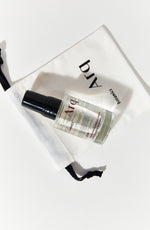 A small, clear spray bottle with a black cap, labeled "Arq Botanics Glow Rose Hyaluronic Kakadu." It's resting inside a white drawstring pouch with the "Arq Botanics" logo.