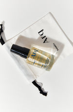 A small, clear spray bottle with a black cap, labeled "Arq Botanics Refresh Hyaluronic Kakadu." It's resting inside a white drawstring pouch with the "Arq Botanics" logo.