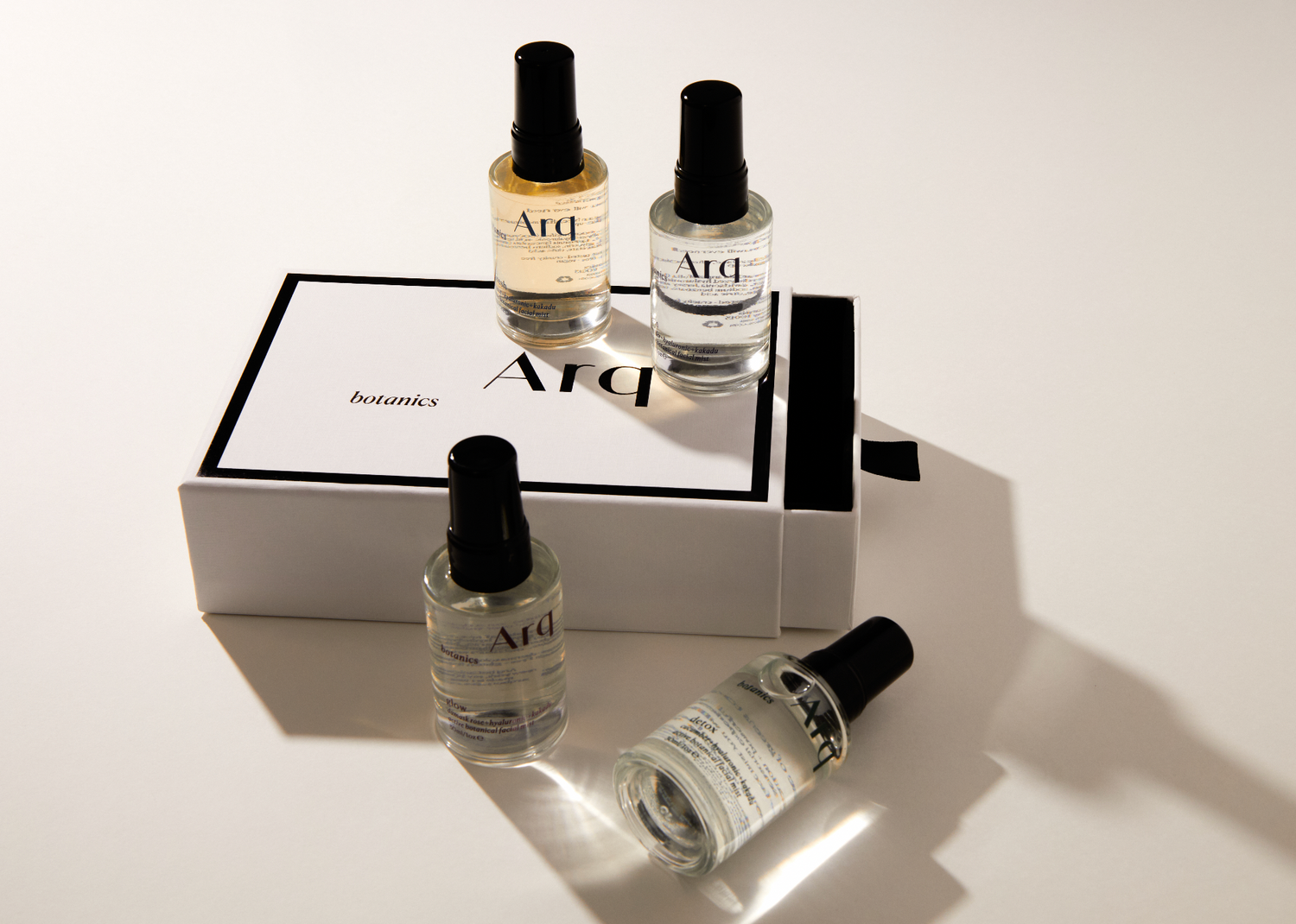 Four elegant perfume bottles arranged on a pristine white surface, showcasing their unique designs and colors.