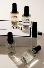 Four elegant perfume bottles arranged on a pristine white surface, showcasing their unique designs and colors.