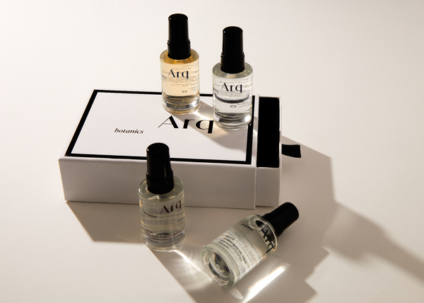 Four elegant perfume bottles arranged on a pristine white surface, showcasing their unique designs and colors.