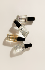 Four bottles of arq perfume arranged neatly on a white surface, showcasing vibrant hues and sleek designs.