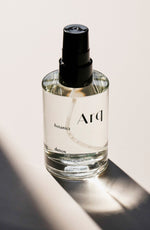 A glass bottle of Arq Botanics Detox Cucumber Hyaluronic Facial Mist with a black spray pump, sitting on a white surface.