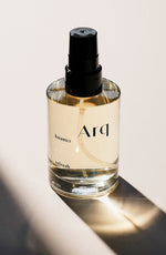 A bottle of arq perfume elegantly placed on a table, showcasing its refined design and captivating fragrance.
